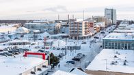 Ilmakuva Kemin keskustasta helmikuussa 2022. Kerrostaloja, autoja, taustalla kaupungintalo. Maassa ja kattojen päällä on lunta. 