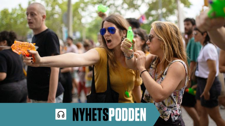 Två kvinnor står med varsin vattenpistol och riktar dem mot turister under en demonstration i Barcelona under sommaren 2024. 