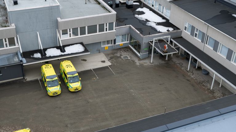 Ilmakuva akuuttipoliklinikan pihasta, pihalla kolme ambulanssia.