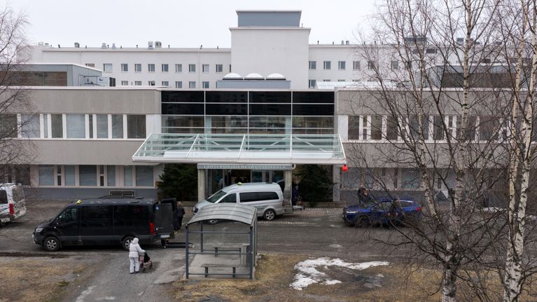 Ilmakuva sairaalasta, jonka edustalla on useampi taksi sekä potilaita tulossa ja lähdössä.