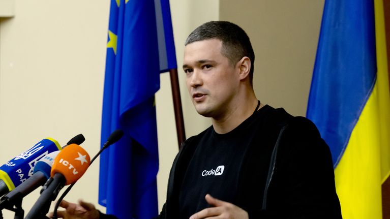 Ukrainas minister för digital omvandling  Mychailo Fedorov står vid ett podium med flera mikrofoner.