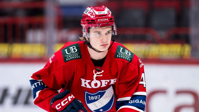 Nuori mies pelaa jääkiekkoa Helsingin IFK:n sinipunaisissa tunnusväreissä. 