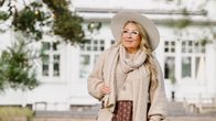Elegantti asukokonaisuus, jossa kuvioitu pitkä hame, mukava neule ja tyylikäs huivi. Kokonaisuuden täydentää vaalea laukku ja leveälierinen hattu.