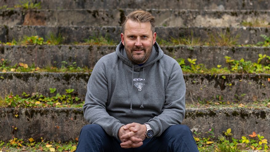 Leijonien päävalmentaja Antti Pennanen istuu kivisillä portailla Ahvenistonjärvellä Hämeenlinnassa.