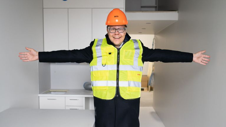 Matti Tarhio levittää käsivartensa näyttääkseen yksiön kokoa.