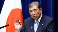 Shigeru Ishiba puhuu Japain lipun vieressä.