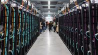 Två rader med serverrack står längs med ett gångutrymme i en industrimiljö.