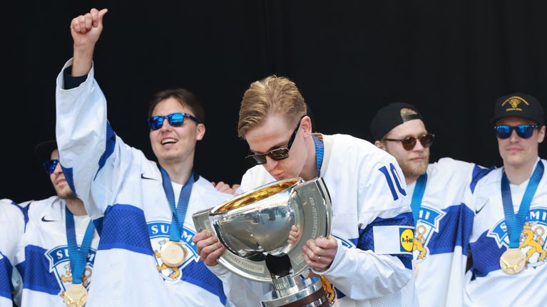 Jääkiekon MM-kultaa voittaneet pelaajat lavalla, edessä vasemmalla Justus Annunen, oikealla Henri Jokiharju.