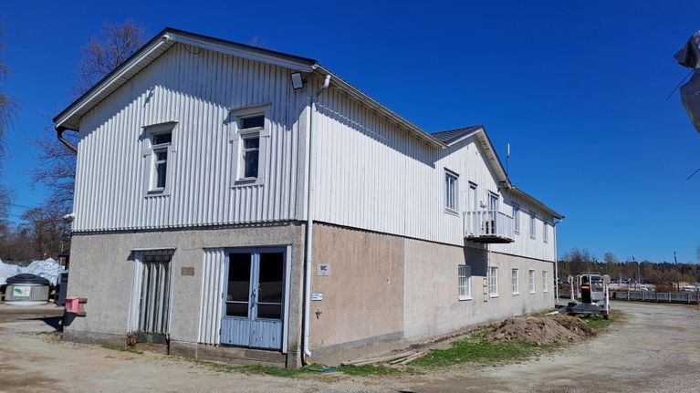 Ett hus i en hamn där det ska byggas parkeringar framför huset.