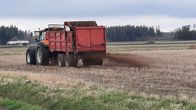 Traktori levittää kuivalantaa pellolle Marttilassa.