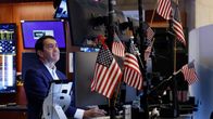 Börsmäklare i New York. I förgrunden syns flera amerikanska flaggor.