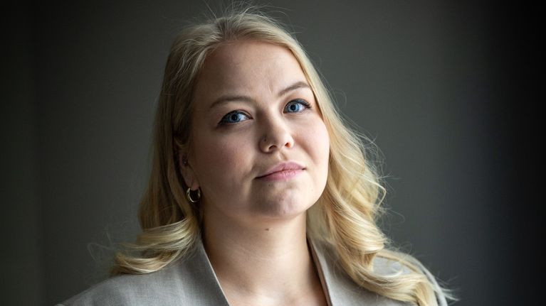 Julia Sieppi  seisoo pukeutuneena jakkupukuun ja katsoo kameraan.
