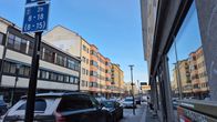 Kokkolan ydinkeskustassa autoja pysäköitynä tien varteen. Taustalla näkyy värikäs kerrostalo.