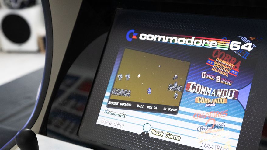 Lähikuva pelihallilaitteesta, jonka näytöllä on Commodore 64 -peli Commando.