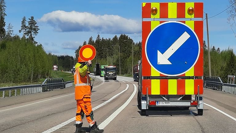 Vägarbete, en man dirigerar trafiken.