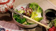Pho-keitto tarjoiltuna kulhossa, joka sisältää vihanneksia, retiisejä, limeä ja sieniä. Aterimena puiset syömäpuikot. Taustalla teekannu ja pieni kulho kastikkeelle.
