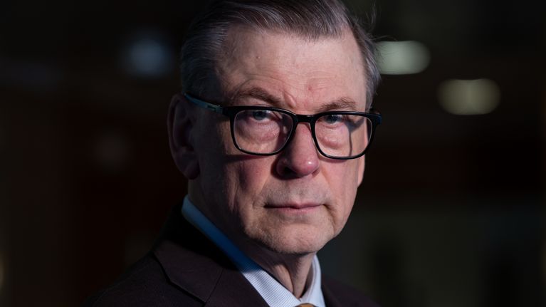 Ilkka Oksala katsoo kameraan päin aulassa.