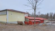 En gul och röd byggnad som varit Kyrkfjärdens skola i Ingå och som nu är ett välfärdscentrum.