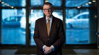 Ilkka Oksala seisoo portaiden päässä aulassa.
