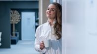 Maria Nyman, utvecklingsdirektör vid Barona, lutar mot väggen med en kaffekopp i handen. 