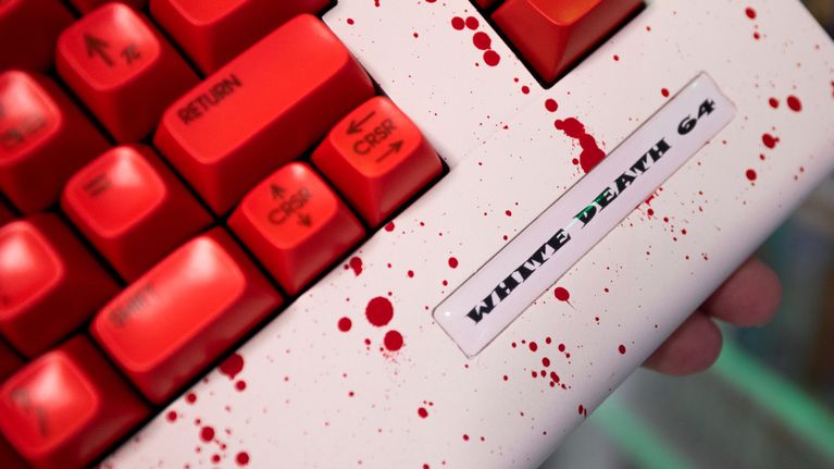 Lähikuva modatusta valkoisesta Commodore 64:stä jossa on veriroiskeita.