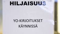 Lasiin kiinnitetty lappu, jossa on teksti Hiljaisuus,  yo-kirjoitukset käynnissä.