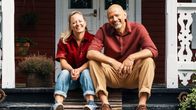 kvinna och man sitter på en trappa på  verandan till en spetsvilla.