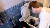 Man loading a washing machine with clothes.