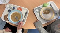 Lautasilla on hernekeittoa ja tarjottimella leipää.