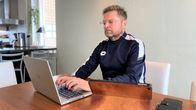 Lahtelainen Mika Halme istuu keittiönsä pöydän ääressä läppärin ja ipadin kanssa ja tekee työtä. Katsoo tietokonensa ruutua ja kirjoittaa.