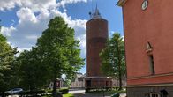 Kokkolan vanha punatiilinen vesitorni kesäisessä kuvassa.