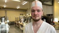 Leipomon miestyöntekijä työvuorossa modernissa leipomossa.