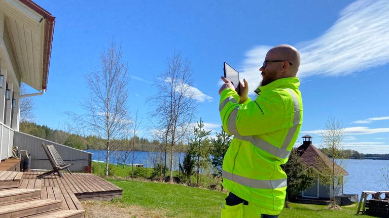 Mänttä-Vilppulan rakennustarkastaja Santtu Markkula on kirkkaan keltaisessa huomioasussa kuvaamasas tablettitietokoneella kiinteistöjä tarkastuskäynnilllään