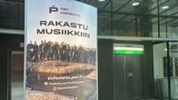 Kauppakäytävän mainoksessa lukee Rakastu musiikkiin.