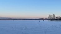 Järven jäätä hämärässä talvimaisemassa kirkkaana päivänä.