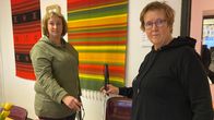 Näkövammaisella Pirjo Heikinjuntilla on kädessään pitempi valkoinen keppi, opaskoiran kanssa liikkuvalla sokealla Jonna Forsellilla lyhyempi koirakeppi. 