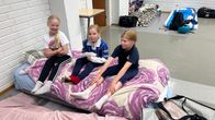 Lapset viettävät aikaa sisätiloihin järjestetyssä yöpymistilassa.