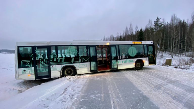 En buss har kört av vägen, framdelen ligger tvärs över vägen medan bakdelen hänger ut över ett dike.