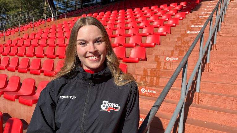 Pesäpalloilija Noora Pasi hymyilee kameralle Joensuun Mailen verkkatakki päällään.