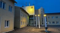 Valaistu vaaleankeltainen suuri rakennus, jonka oven yläpuolella lukee "Kunnantalo". 