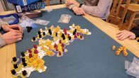 Four youths playing a board game on a table.