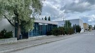 Valkoisista tiilistä rakennettu talo, jossa on isot verhoilla peitetyt ikkunat. 