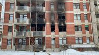 Bostadshus vars vägg har stora sotfläckar efter en brand. 