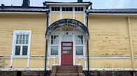 Keltainen puurakennus, jonne johtaa kivirappuset.