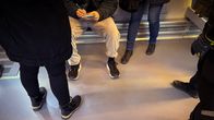 Photo shows inspectors checking a passenger's ticket.