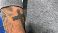 Risti-tatuointi käsivarressa.