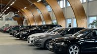 Myytäviä autoja rivissä autokaupan myyntihallissa.