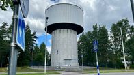 Kouvolan Tornionmäen vesitorni ja sen uusi aitaus kuvattuna suojatien vierestä kadun vastakkaiselta puolelta.