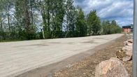 Sorapintainen pysäköintialue tien varrella vehreässä ympäristössä.