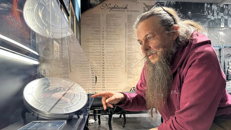 Parrakas mies tutkii Nightwish-näyttelyn vitriinissä esillä olevia tavaroita.